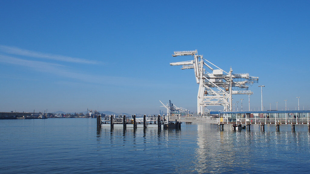 Ship-to-shore gantry cranes at the Port of Oakland seen from the water on a clear day